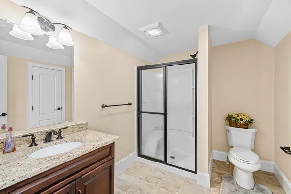 a bathroom with a granite countertop sink toilet and shower