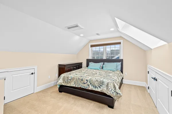 a bedroom with a bed a window and dresser