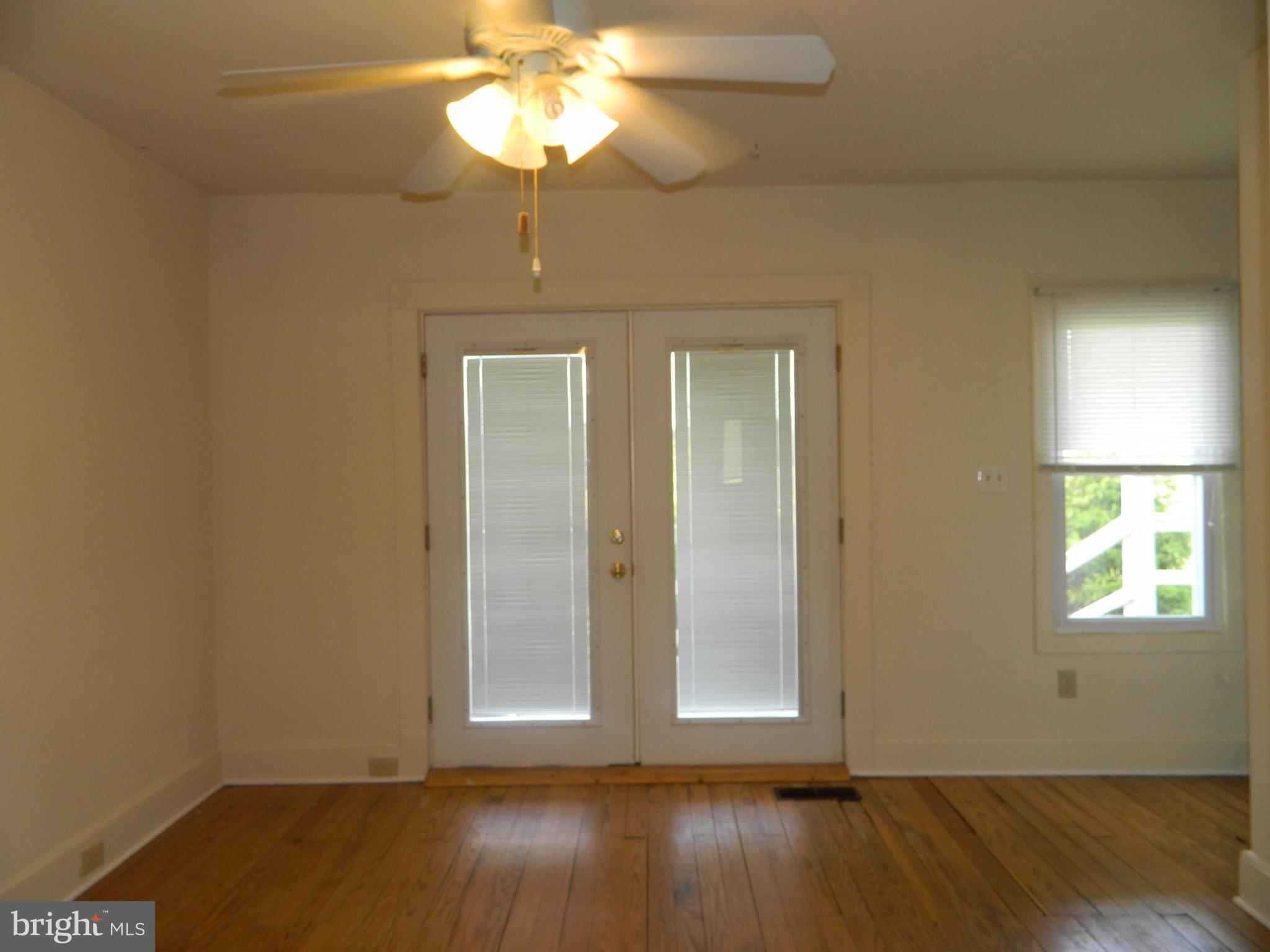 1601 Freeland Road Freeland, MD 21053 - Photo 12 of 29 an empty room with wooden floor chandelier fan and windows