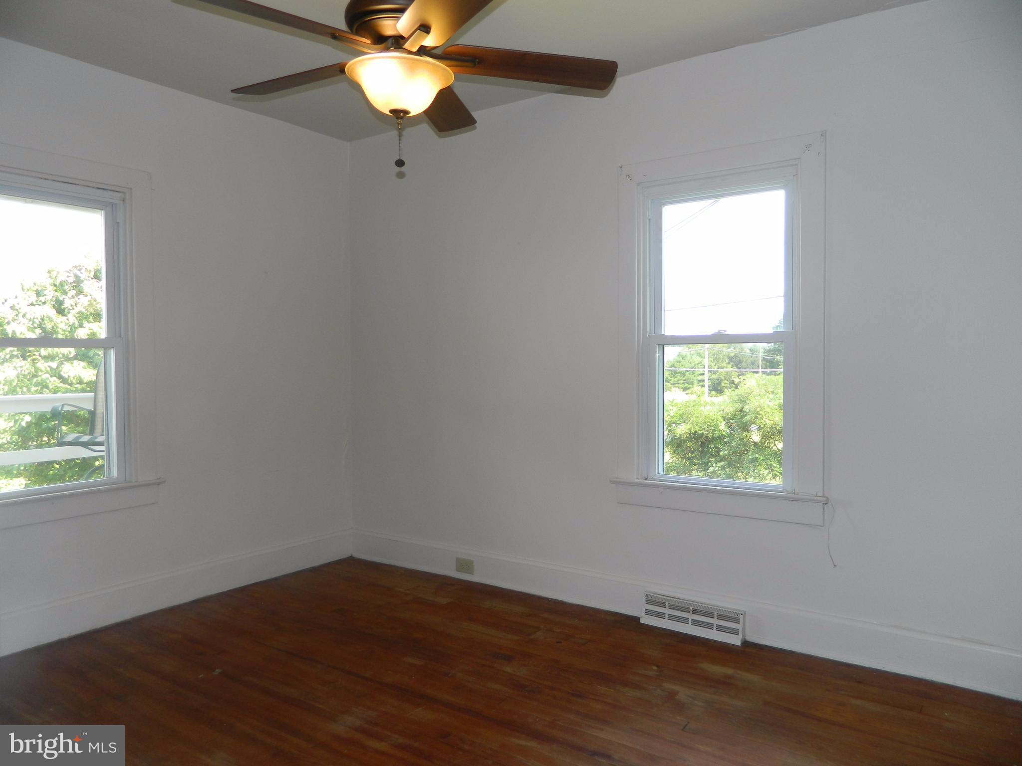 1601 Freeland Road Freeland, MD 21053 - Photo 18 of 29 an empty room with wooden floor fan and windows