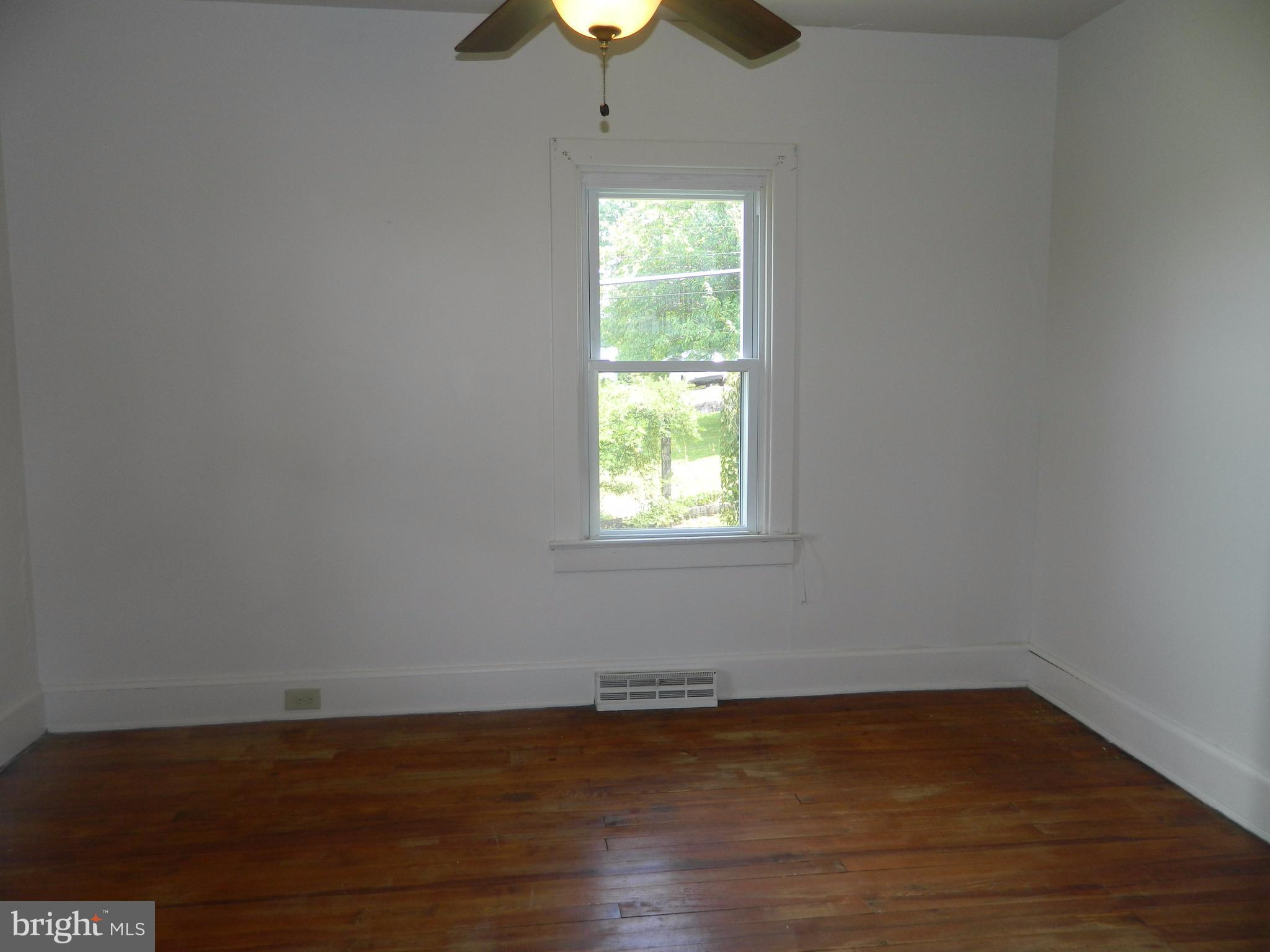 1601 Freeland Road Freeland, MD 21053 - Photo 19 of 29 a view of an empty room with wooden floor fireplace and a window
