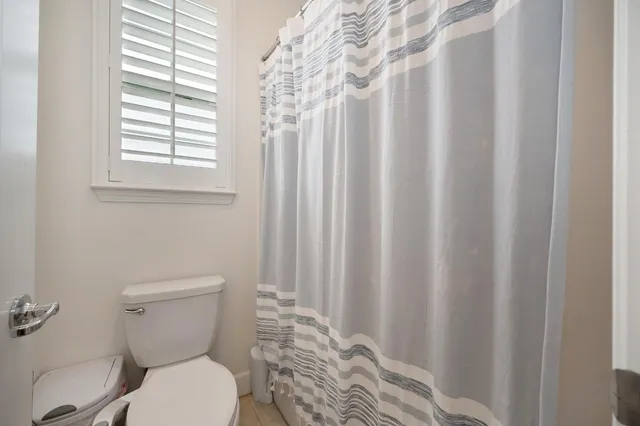 a white toilet sitting next to a shower curtain