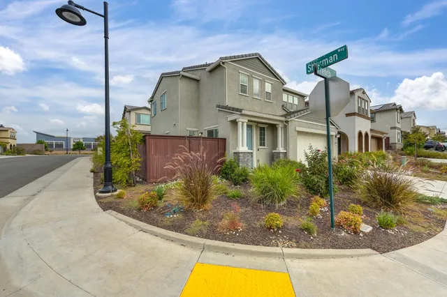 a view of a house with a small yard and sitting area