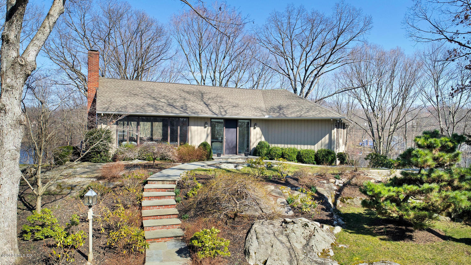1 Lia Fail Way Cos Cob, CT 06807 - Photo 19 of 26 a front view of a house with a yard covered with trees