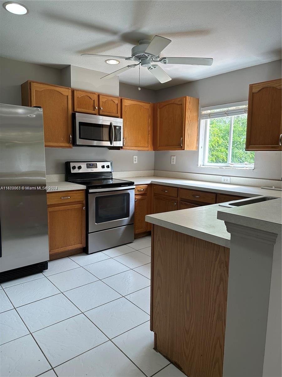 Avalon Miramar, FL 33025 - Photo 3 of 14 a kitchen with stainless steel appliances a sink a stove a microwave and cabinets