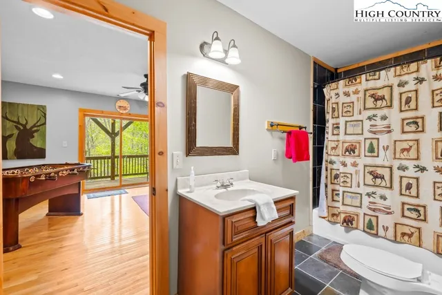 a bathroom with a sink a toilet a mirror and shower