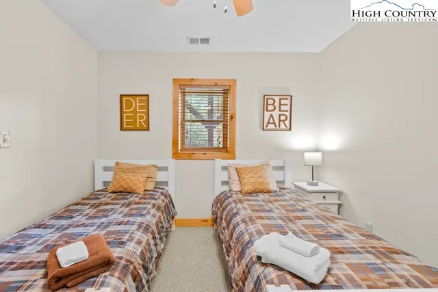 a bedroom with two beds and a lamp