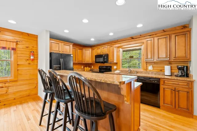 a kitchen with stainless steel appliances granite countertop sink stove top oven and cabinets