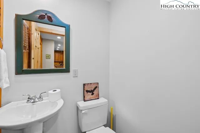 a bathroom with a toilet sink vanity and mirror