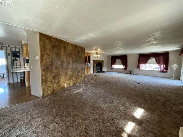 a view of a livingroom with wooden floor and a fireplace