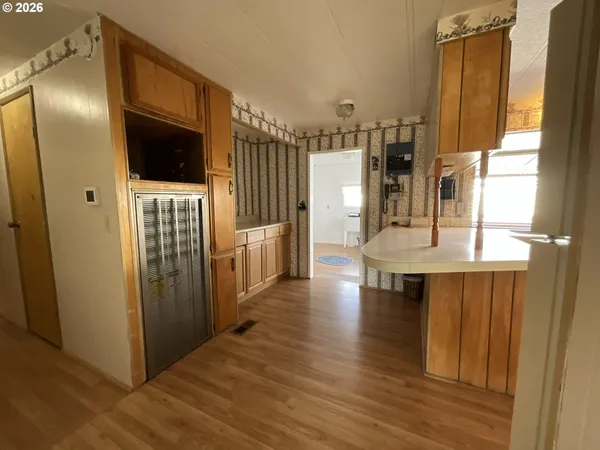 a view of a living room with a wooden floor and a kitchen