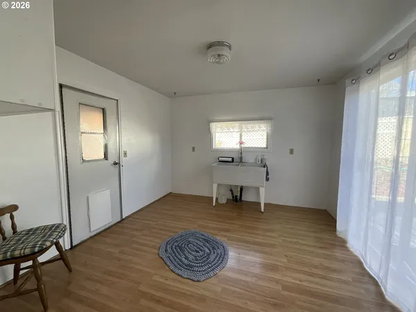 a view of a livingroom with wooden floor and a window