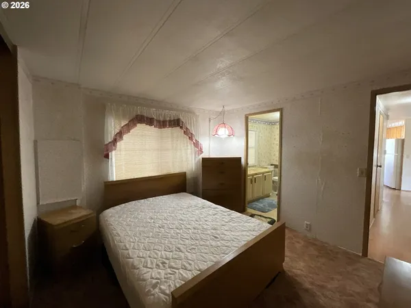 a bedroom with a large bed and a dresser