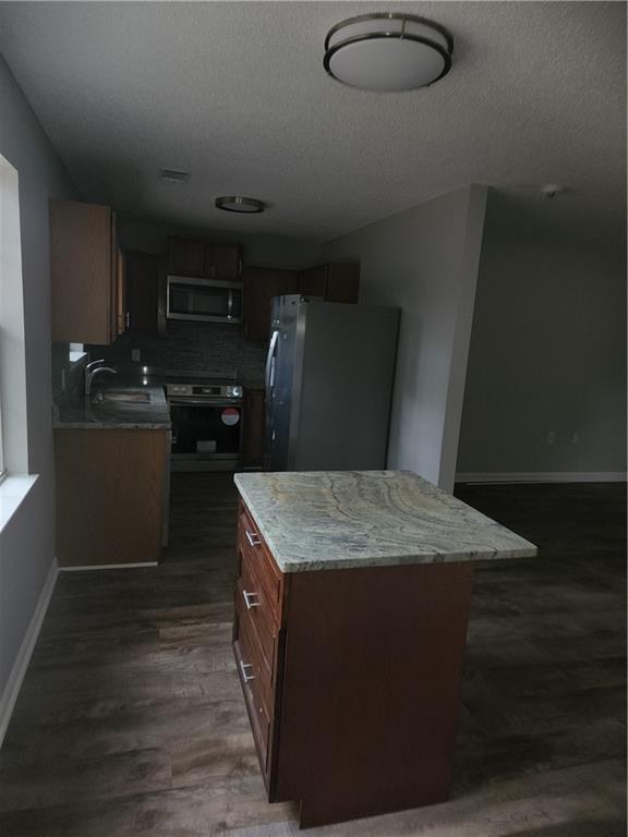 6130 Geiger Street Northwest Covington, GA 30014 - Photo 14 of 23 a kitchen with kitchen island stainless steel appliances a sink stove and refrigerator