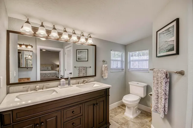 a spacious bathroom with a toilet sink and mirror