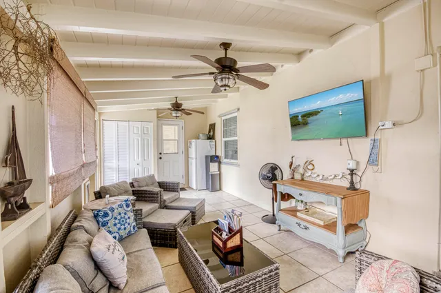 a living room with furniture a flat screen tv and a window
