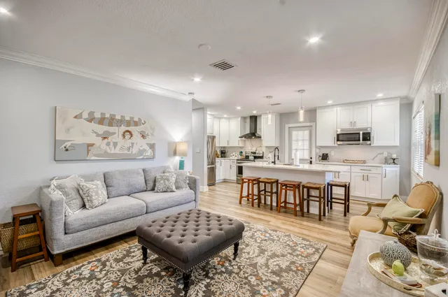 a living room with stainless steel appliances kitchen island granite countertop a couch and white cabinets