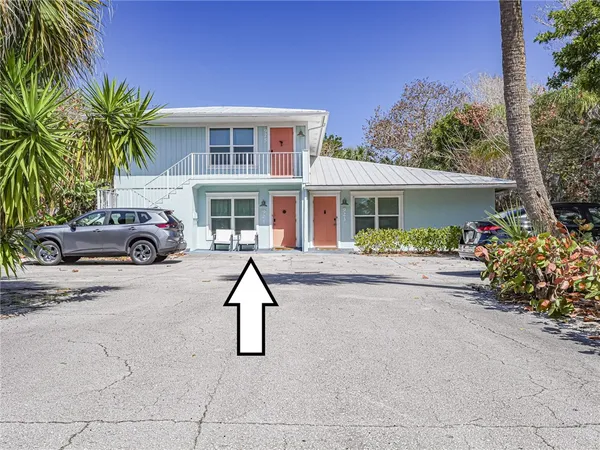 a front view of a house with garden and parking