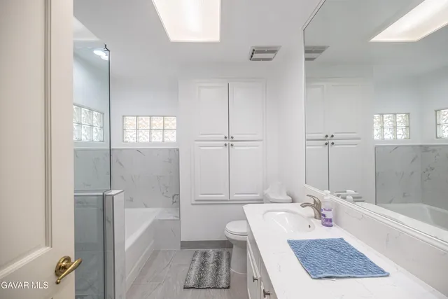 a bathroom with a tub a sink and a large mirror