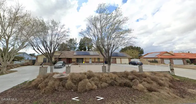 a front view of a building with large trees