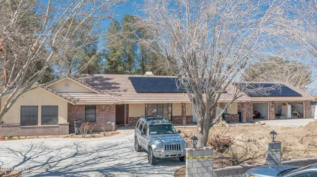 a front view of a house with a yard covered with snow in front of house