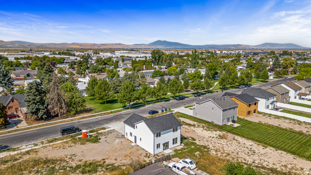 612 North 400 West Logan, UT 84321 - Photo 11 of 27 Newly constructed residence featuring a white exterior with dark shutters, a dark shingle roof, and an attached two-car garage