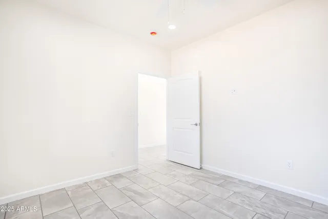 an empty room with a ceiling fan and a window