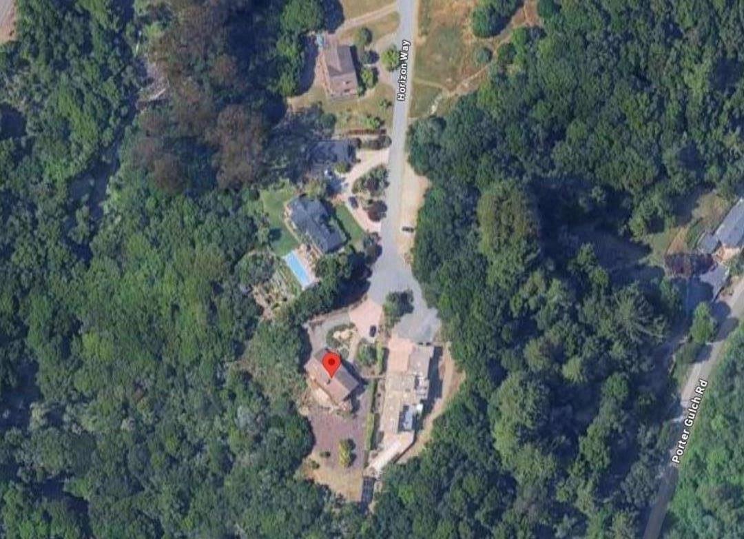 an aerial view of residential house with outdoor space and trees all around