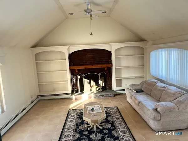 a living room with furniture a fireplace and a potted plant