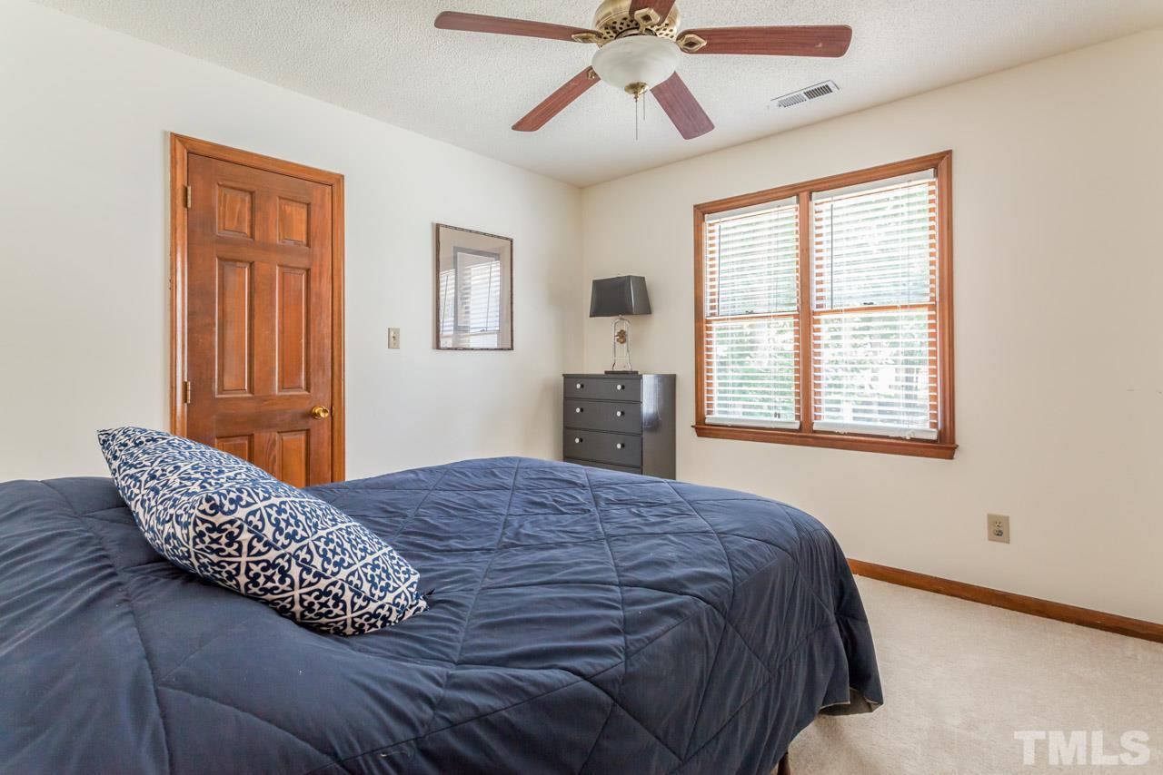 6679 English Ivy Lane Raleigh, NC 27615 - Photo 14 of 24 a bedroom with a bed and wooden floor