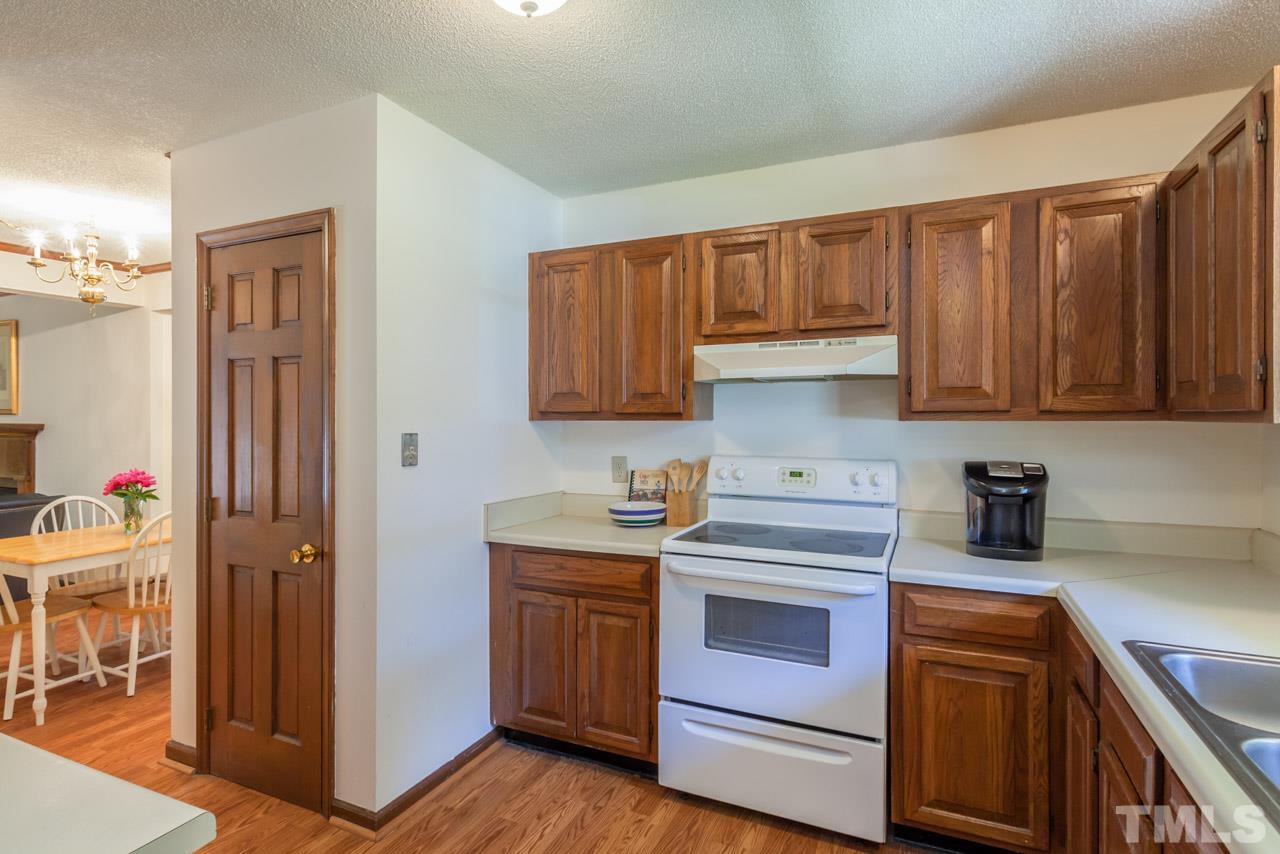 6679 English Ivy Lane Raleigh, NC 27615 - Photo 5 of 24 a kitchen with stainless steel appliances granite countertop a stove and a refrigerator