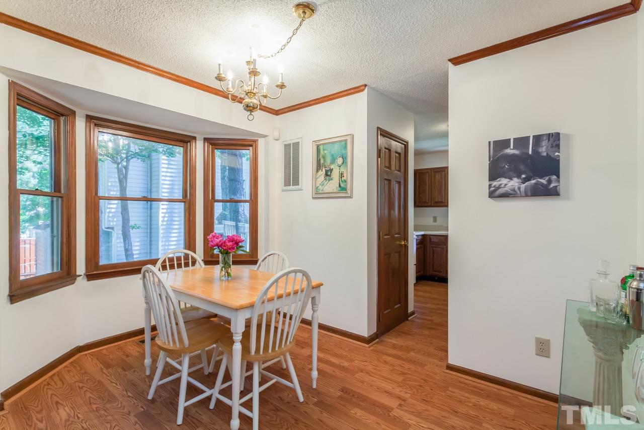 6679 English Ivy Lane Raleigh, NC 27615 - Photo 6 of 24 a dining room with furniture a chandelier and wooden floor