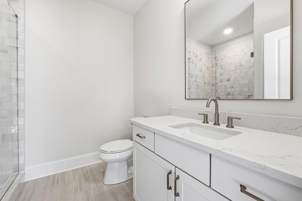 286 County Road Southwest Marietta, GA 30064 - Photo 33 of 40 a bathroom with a granite countertop sink a toilet and a mirror