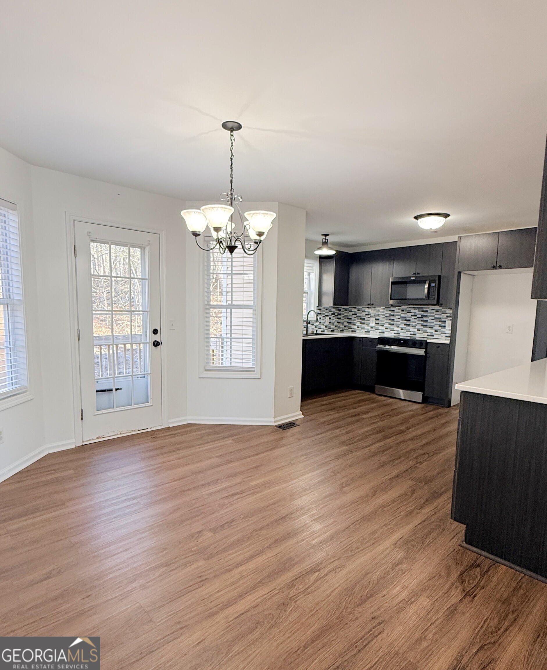 3395 Woodlake Lane Villa Rica, GA 30180 - Photo 6 of 25 a view of a room with wooden floor and kitchen view