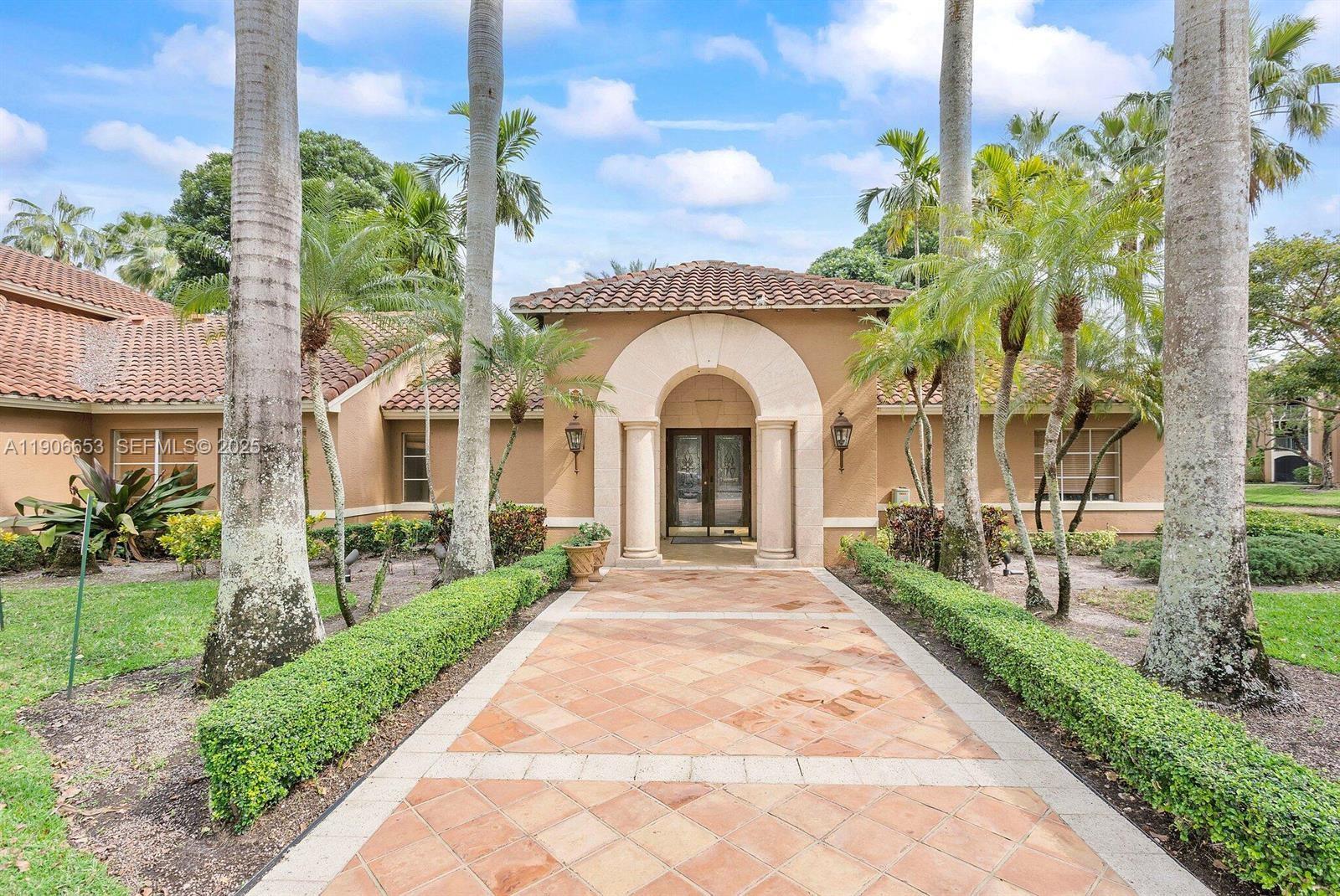 4852 Highway 7, Unit 303 Coconut Creek, FL 33073 - Photo 14 of 26 a front view of a house with a garden and entryway