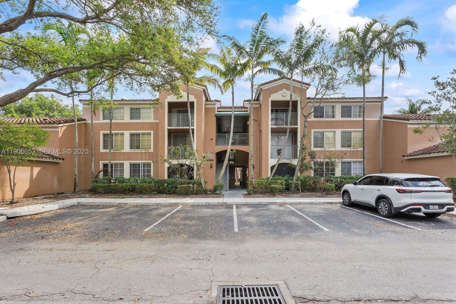 4852 Highway 7, Unit 303 Coconut Creek, FL 33073 - Photo 2 of 26 a front view of a residential apartment building with a yard