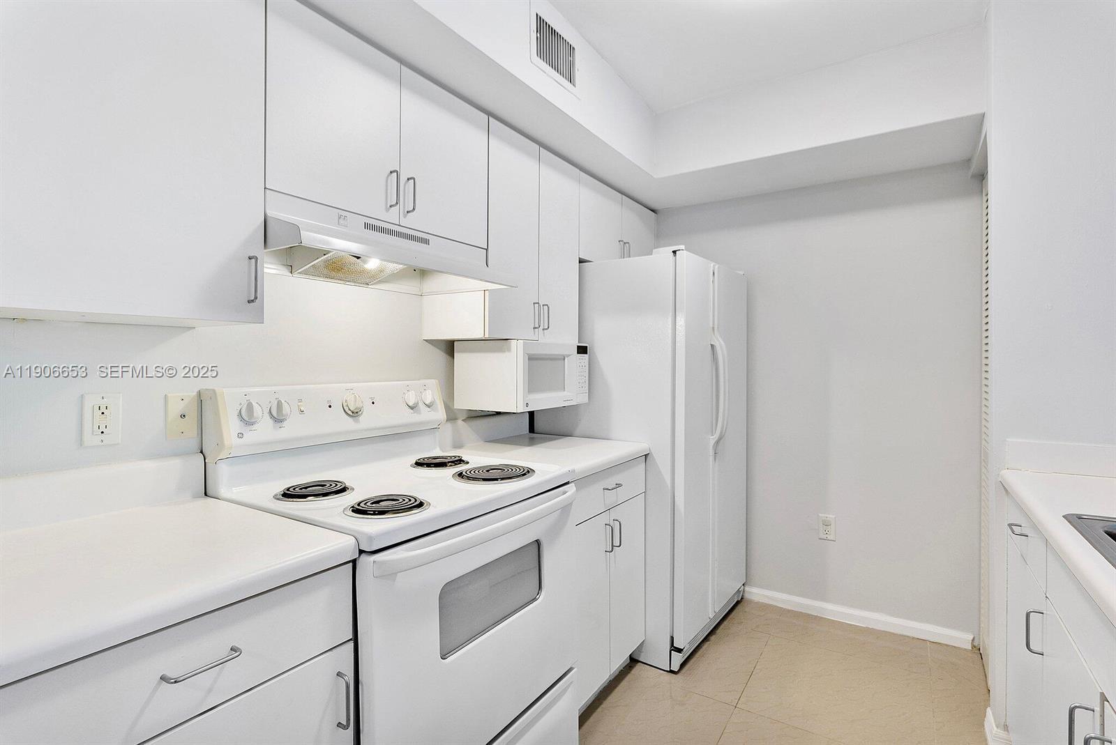 4852 Highway 7, Unit 303 Coconut Creek, FL 33073 - Photo 8 of 26 a kitchen with stainless steel appliances a stove a refrigerator and cabinets