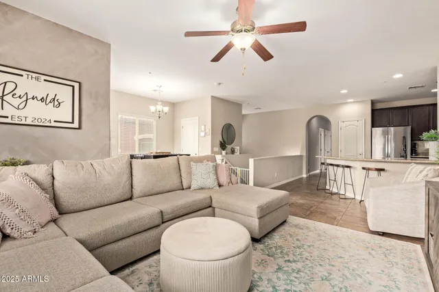 a living room with furniture and a view of kitchen