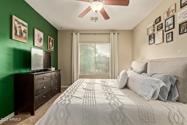 a spacious bedroom with a large bed and a flat tv screen on dresser