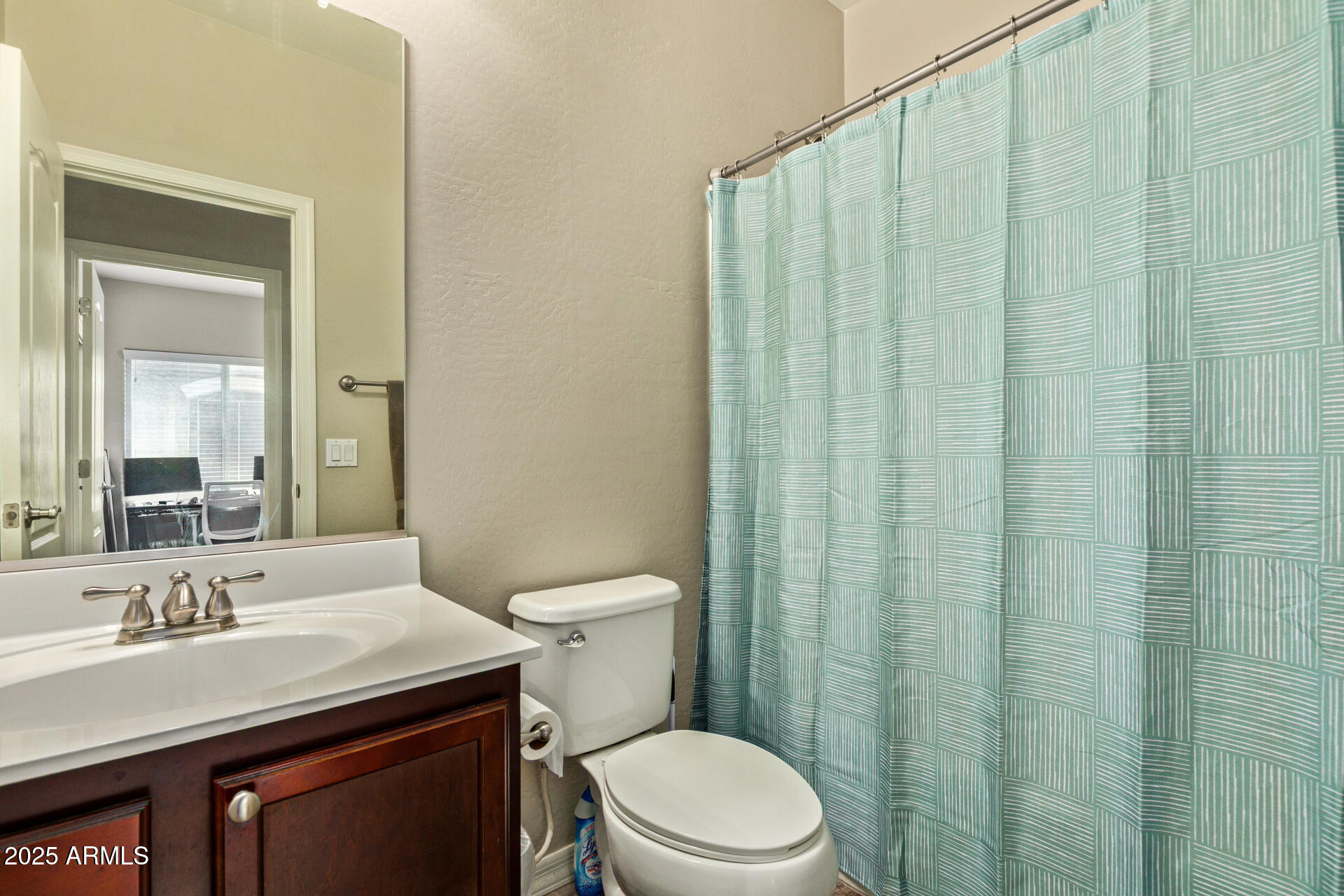 7726 East Baseline Road, Unit 234 Mesa, AZ 85209 - Photo 18 of 31 a bathroom with a sink a toilet a mirror and shower curtain