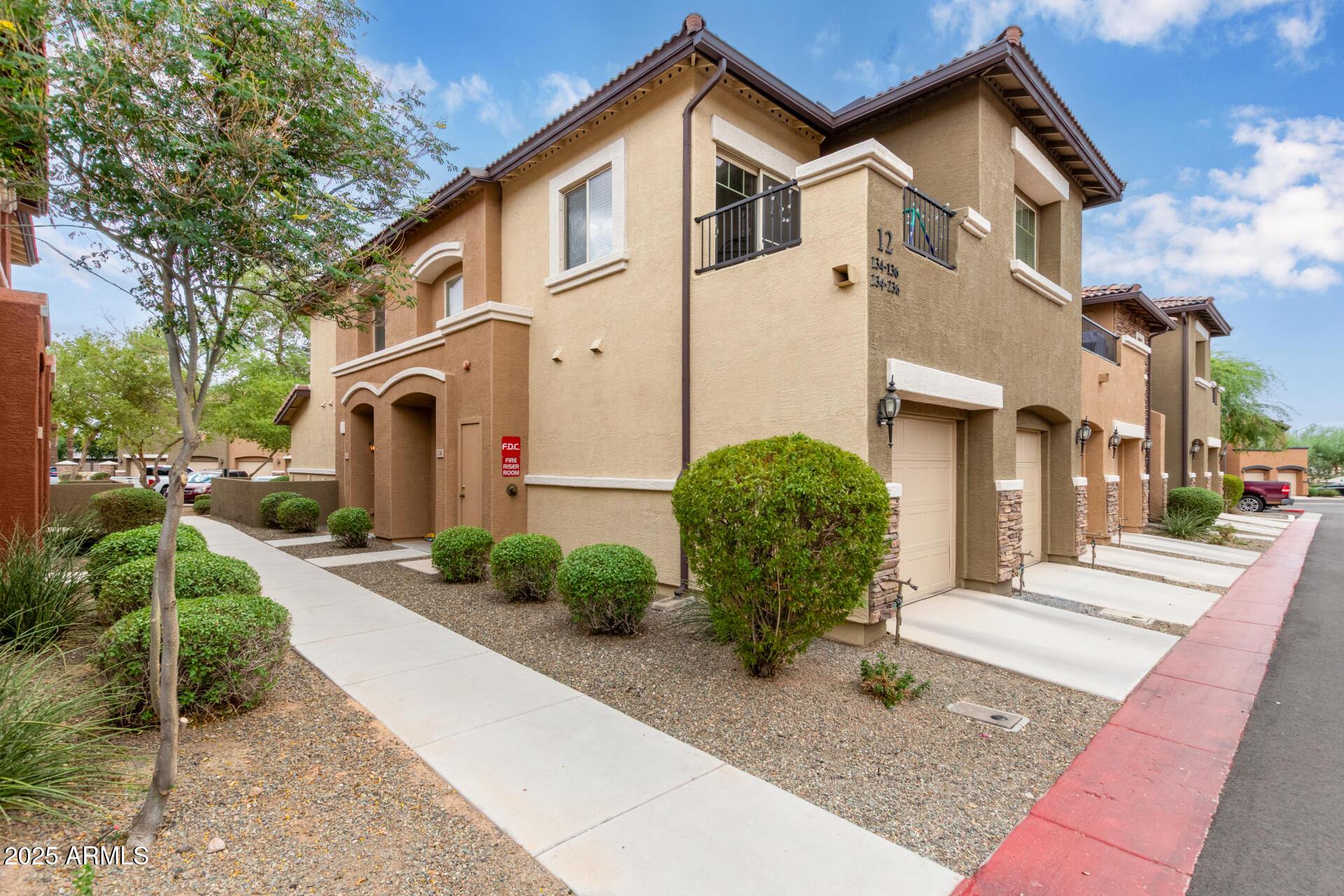 7726 East Baseline Road, Unit 234 Mesa, AZ 85209 - Photo 21 of 31 a view of a white house with a small yard and plants
