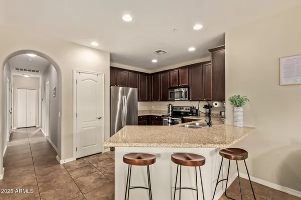 a kitchen with stainless steel appliances granite countertop a refrigerator and a stove