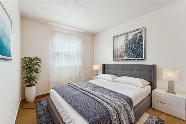 a bedroom with a bed and a potted plant