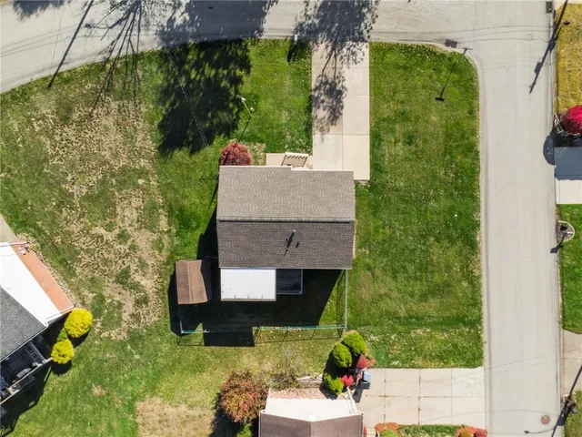 an aerial view of a house with garden space and street view