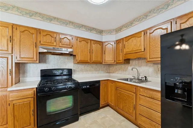 a kitchen with stainless steel appliances granite countertop white cabinets stove top oven and sink
