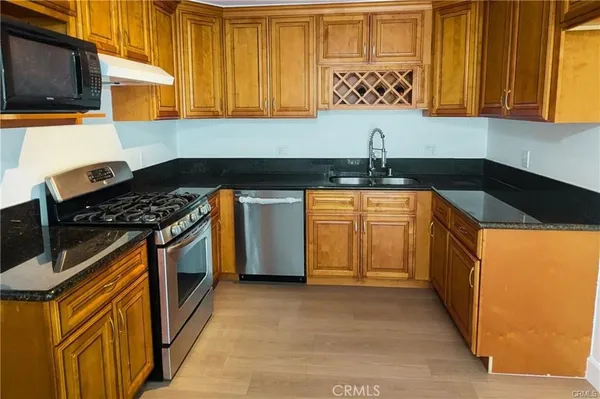 a kitchen with stainless steel appliances granite countertop a sink and a stove top oven