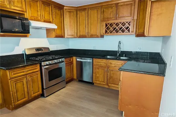 a kitchen with granite countertop cabinets stainless steel appliances and a sink