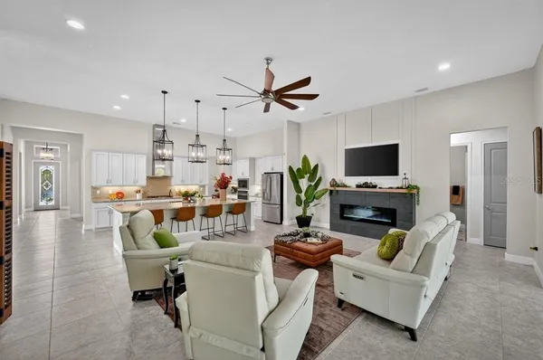 a living room with a fireplace a potted plant and a window