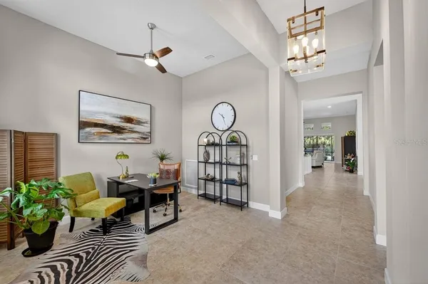 a spacious bedroom with a large bed a chandelier and windows