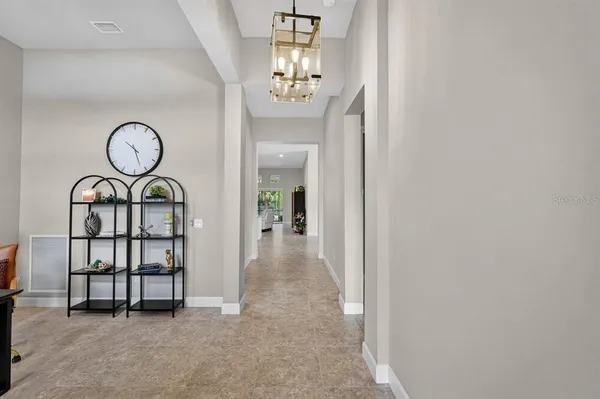 a spacious bedroom with a large bed a chandelier and a rug